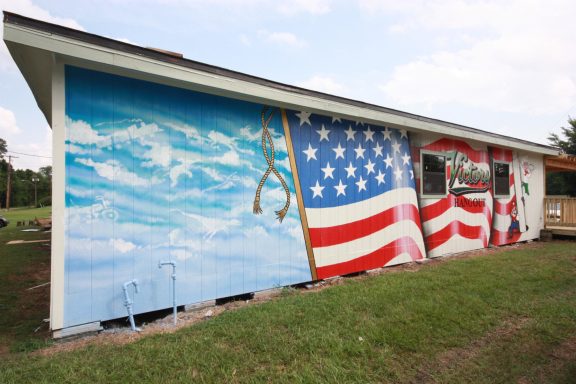 Mural of sky with U.S.A. Banner on building wall