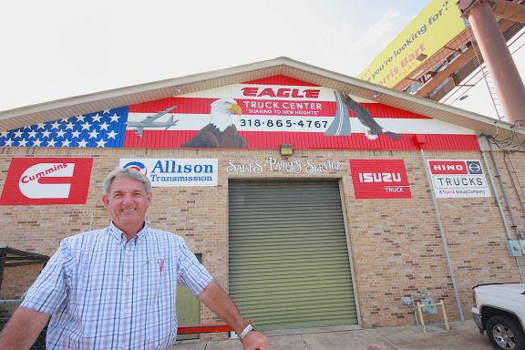 Mural painted on outside of business with U. S. A. Banner, eagle and man standing in front of building