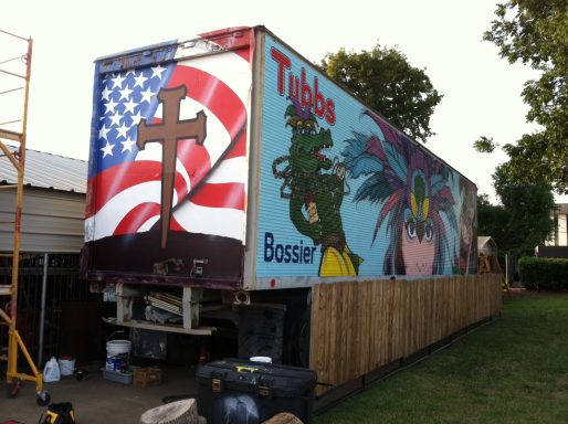 Trailer painted with mural of U. S. A. Banner and cross